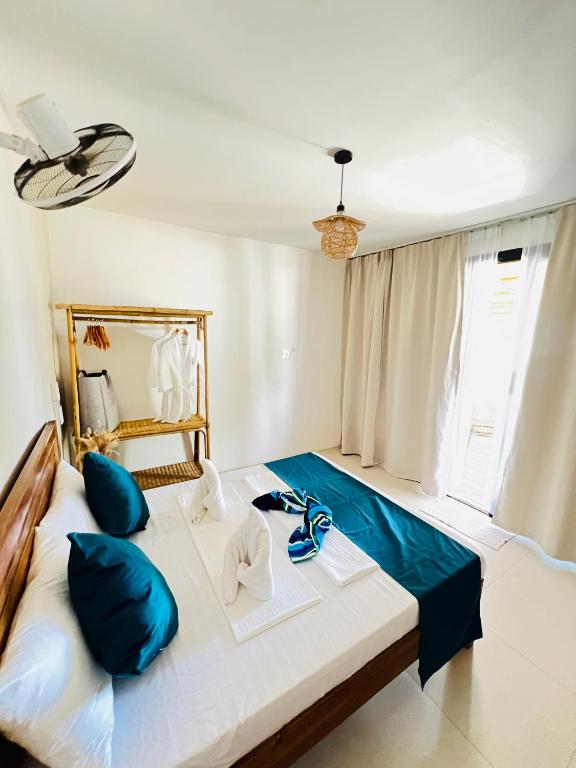 Bright, airy guest room with wooden bed, teal runner and balcony doors